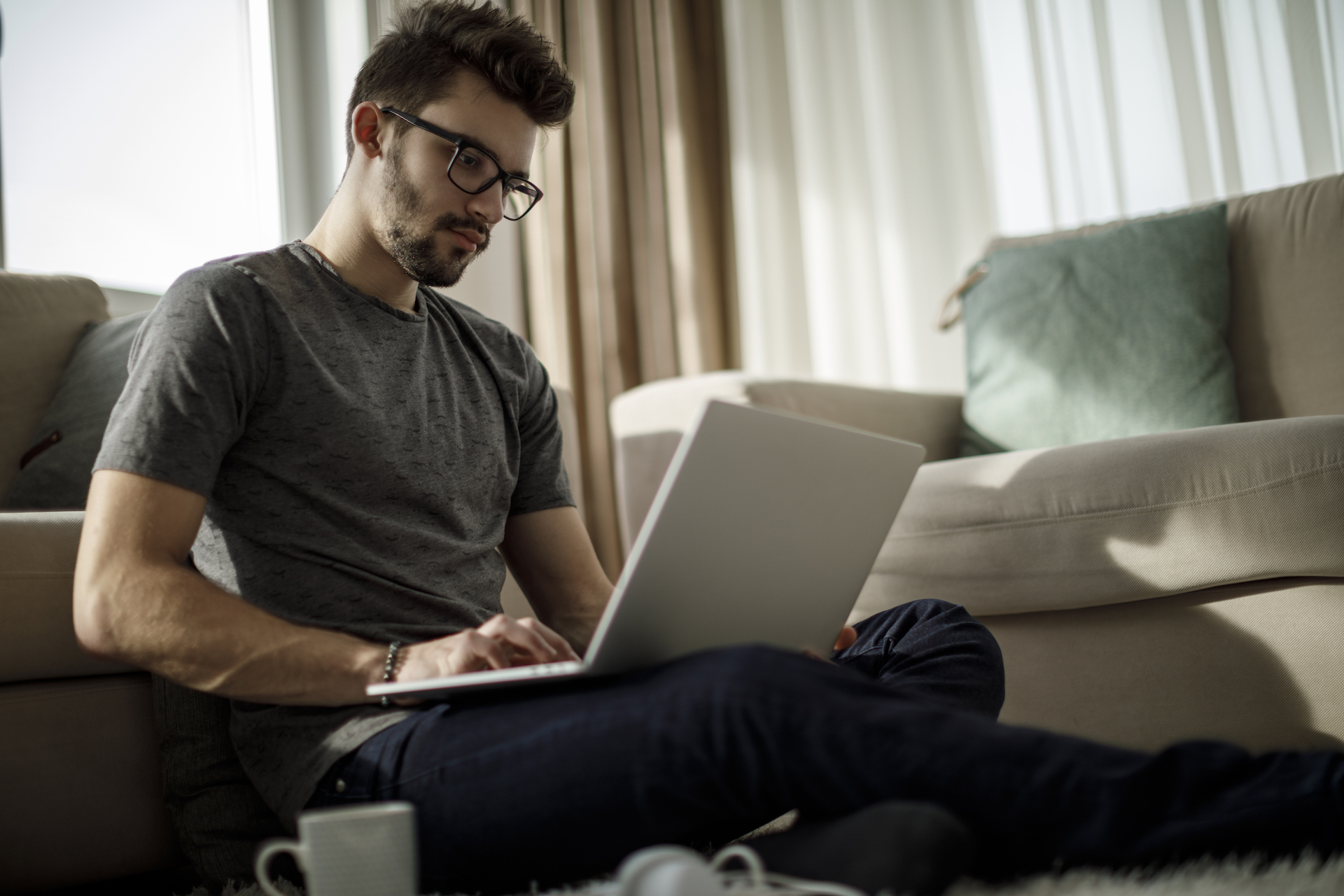 Teenage boy working on laptop at home